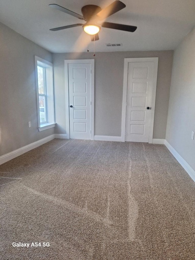 unfurnished bedroom featuring ceiling fan and carpet floors