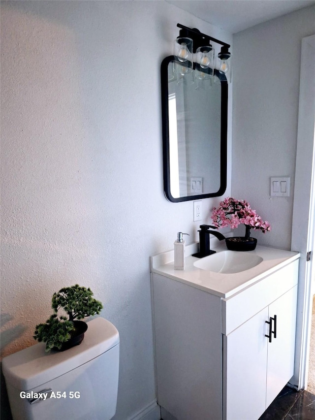 bathroom with tile patterned flooring, vanity, and toilet