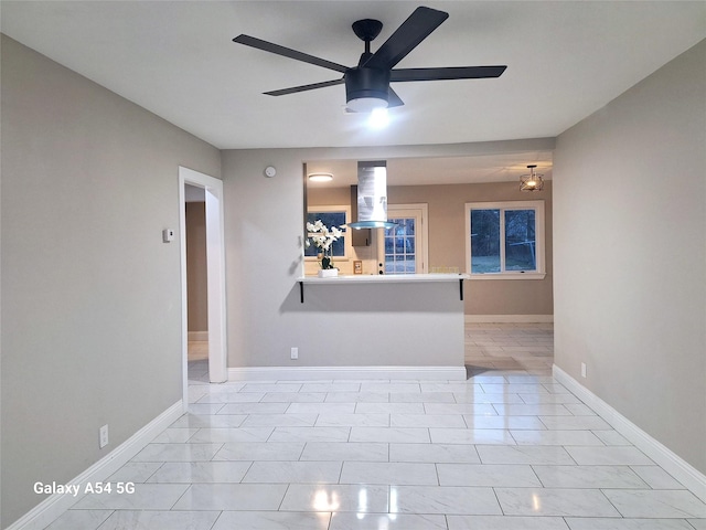 empty room with ceiling fan and light tile patterned floors