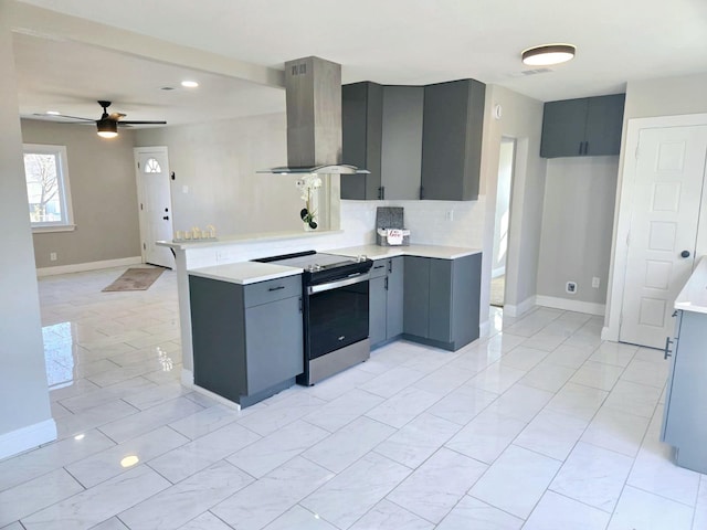 kitchen featuring kitchen peninsula, decorative backsplash, wall chimney exhaust hood, ceiling fan, and stainless steel range with electric cooktop