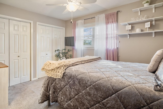 carpeted bedroom with multiple closets and ceiling fan