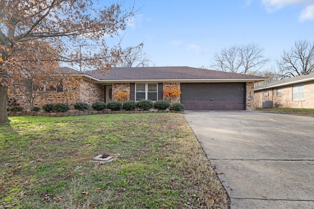 ranch-style home with central AC, a front lawn, and a garage