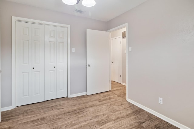 unfurnished bedroom with a closet and light wood-type flooring