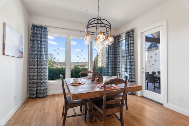 dining area with a chandelier and light hardwood / wood-style floors