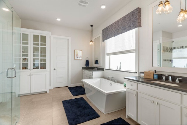 bathroom with tile patterned flooring, vanity, and separate shower and tub