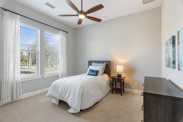 carpeted bedroom featuring multiple windows and ceiling fan