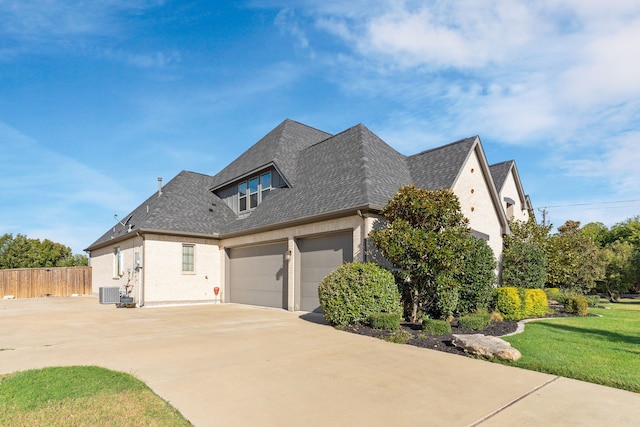 view of property exterior featuring a yard, a garage, and central air condition unit