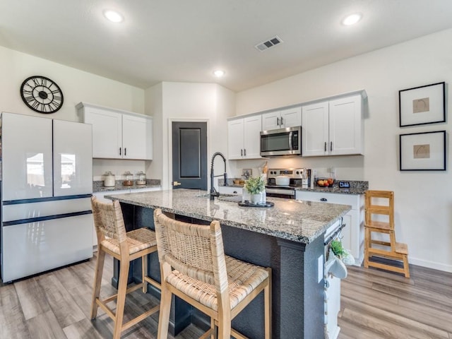 kitchen with white cabinetry, a kitchen island with sink, and appliances with stainless steel finishes