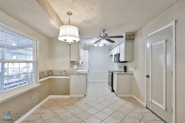 kitchen with pendant lighting, a textured ceiling, a wealth of natural light, and electric stove