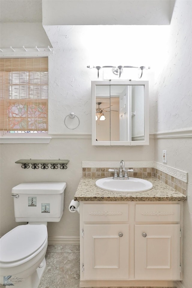 bathroom featuring tasteful backsplash, tile patterned floors, vanity, and toilet