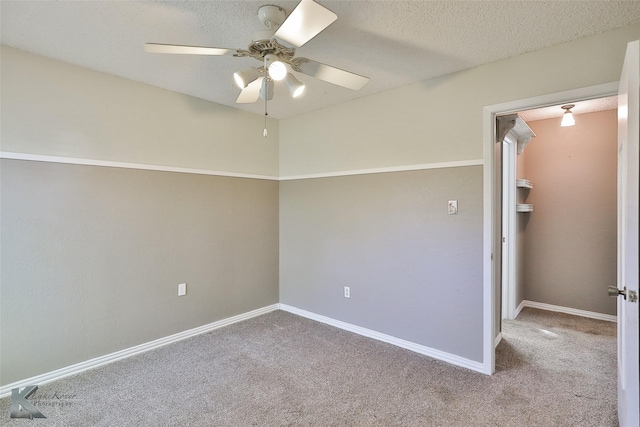 carpeted spare room featuring ceiling fan and a textured ceiling