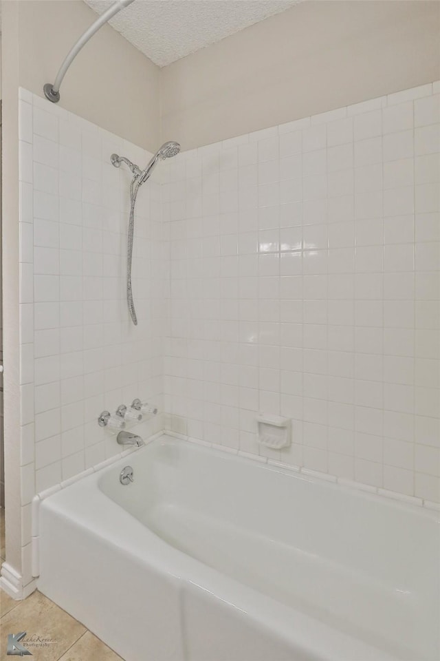 bathroom with tile patterned flooring, a textured ceiling, and bathing tub / shower combination