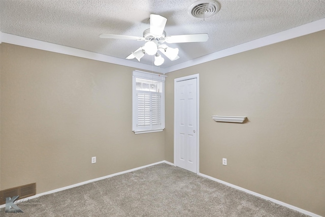 spare room featuring light carpet, ceiling fan, and a textured ceiling