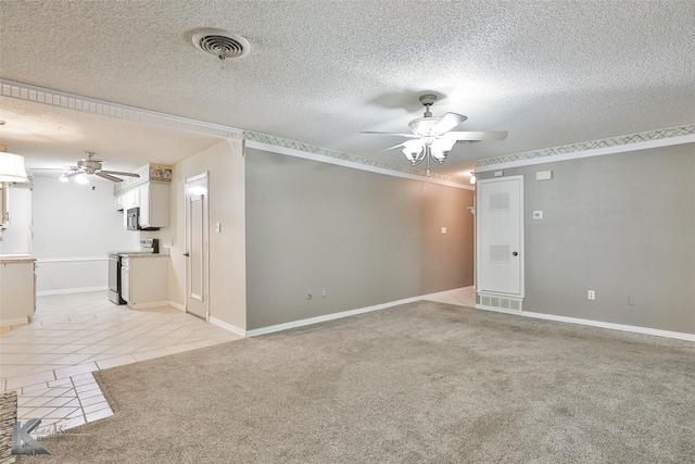 empty room featuring ceiling fan, light colored carpet, and a textured ceiling