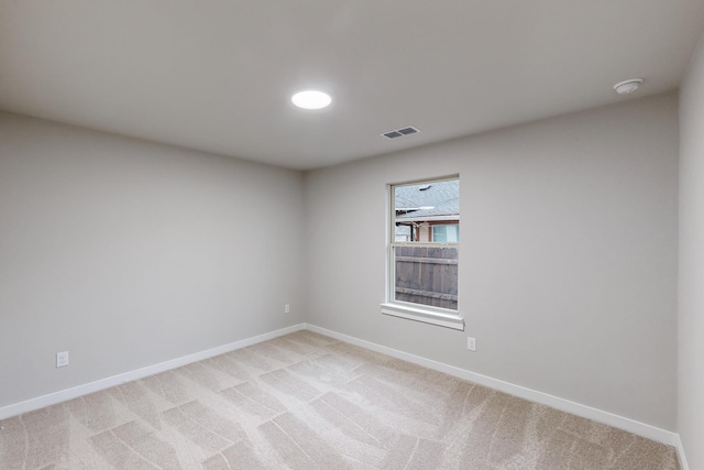 spare room featuring light colored carpet