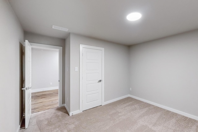 unfurnished bedroom featuring a closet and light colored carpet