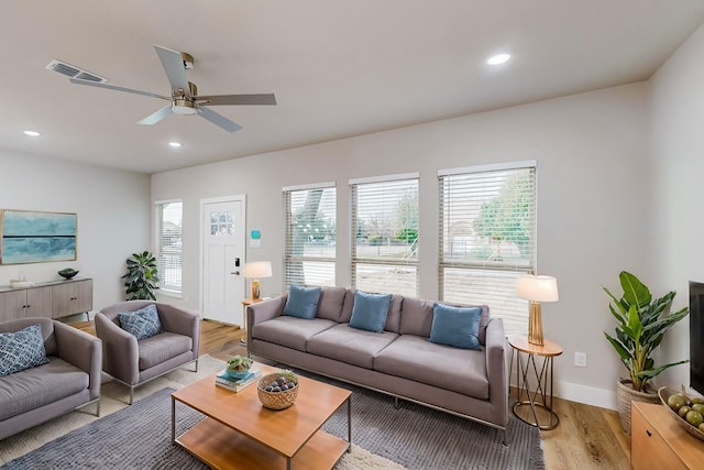 living room with ceiling fan and light hardwood / wood-style flooring