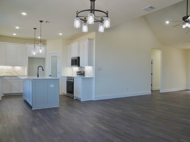 kitchen featuring pendant lighting, white cabinetry, a center island with sink, and appliances with stainless steel finishes