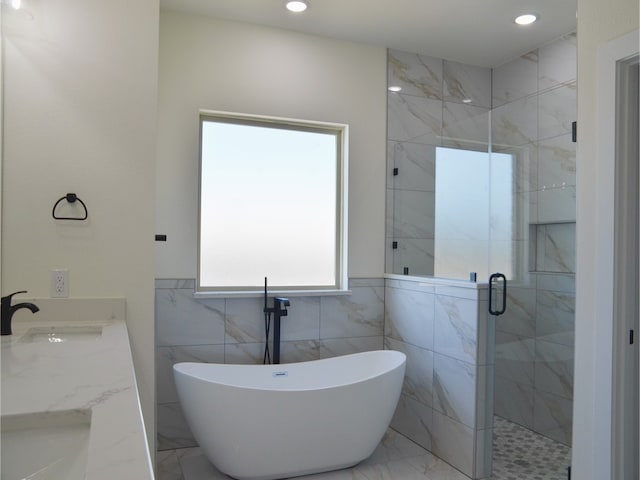 bathroom with vanity and shower with separate bathtub