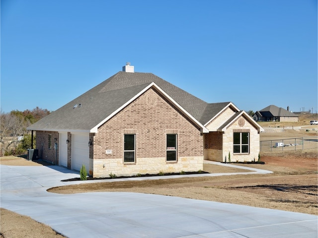 view of front of home featuring a garage and central AC