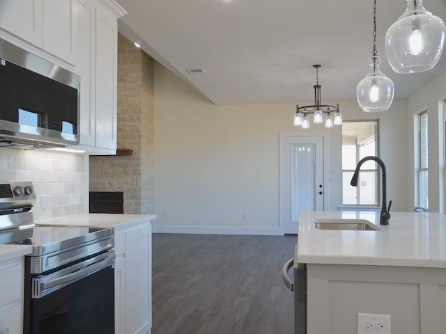 kitchen with sink, hanging light fixtures, tasteful backsplash, white cabinetry, and stainless steel appliances