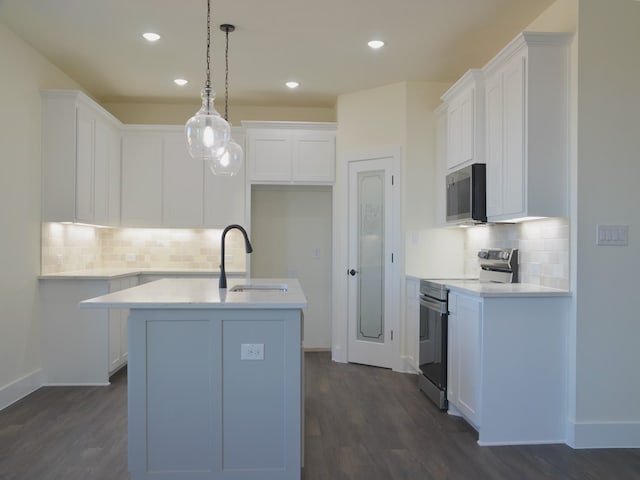 kitchen featuring white cabinetry, sink, decorative light fixtures, stainless steel electric range, and a kitchen island with sink