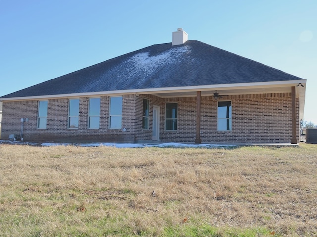 rear view of property featuring a lawn