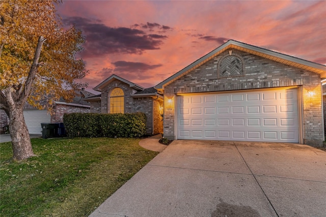 ranch-style house with a garage and a lawn