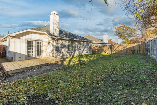 back of house with a lawn, a wooden deck, and french doors