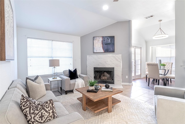 tiled living room featuring a fireplace and vaulted ceiling