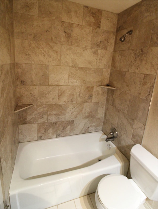 bathroom featuring tile patterned flooring, toilet, and tiled shower / bath