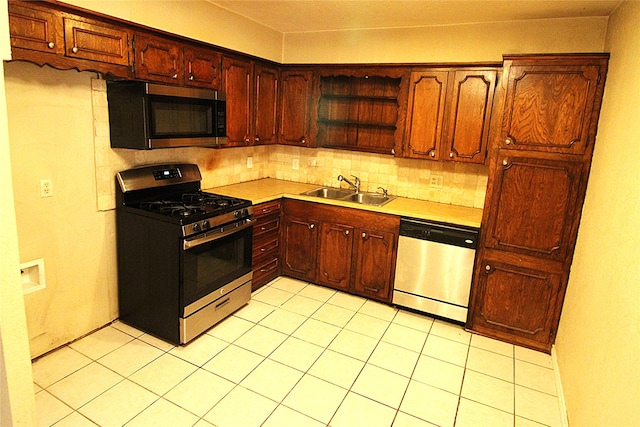 kitchen with light tile patterned floors, stainless steel appliances, tasteful backsplash, and sink