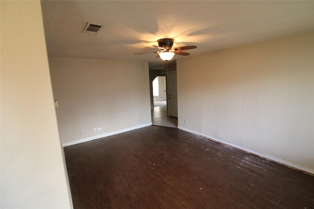 unfurnished room featuring ceiling fan and dark wood-type flooring