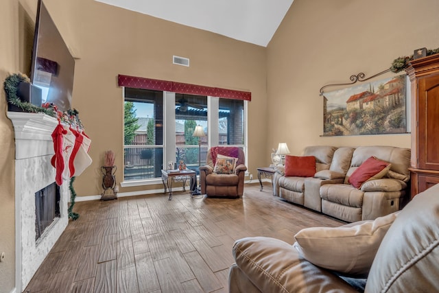 living room featuring high vaulted ceiling and light hardwood / wood-style flooring