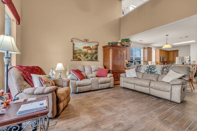 living room with a high ceiling and light hardwood / wood-style flooring