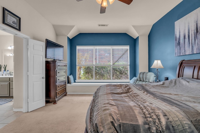 carpeted bedroom with ceiling fan, lofted ceiling, and ensuite bathroom