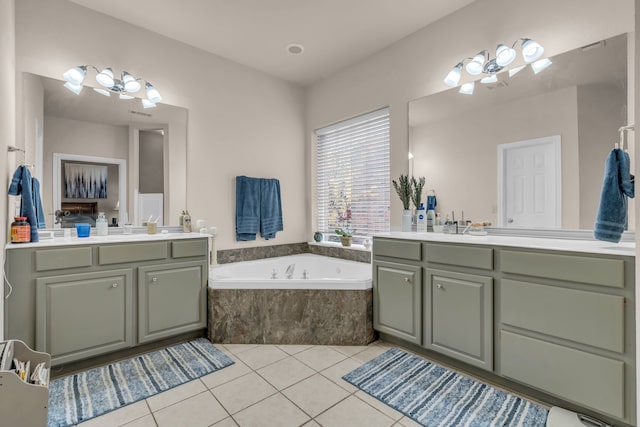 bathroom with vanity, a relaxing tiled tub, and tile patterned floors