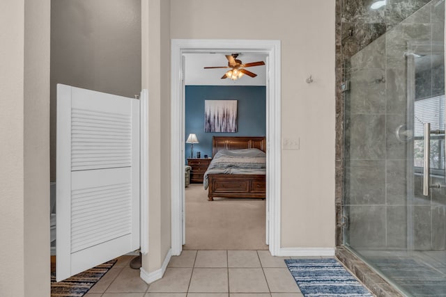 bathroom with tile patterned flooring, ceiling fan, and walk in shower