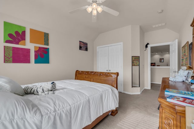 carpeted bedroom with vaulted ceiling, a closet, and ceiling fan