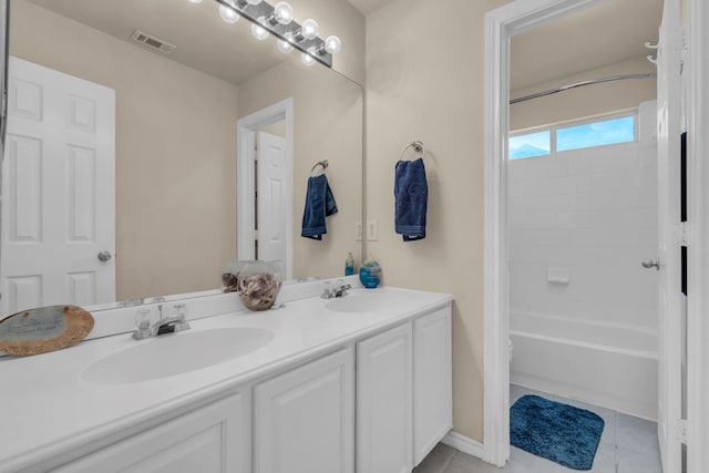 bathroom with washtub / shower combination, vanity, and tile patterned flooring