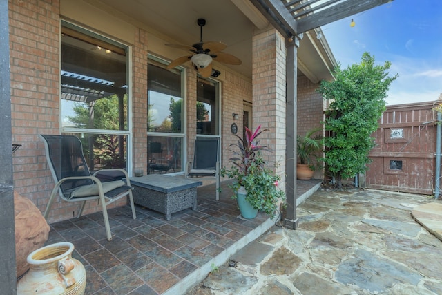 view of patio / terrace featuring a fireplace and ceiling fan