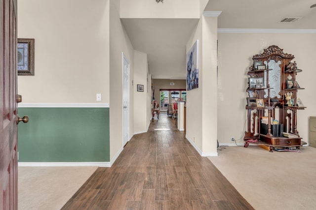 corridor with hardwood / wood-style flooring and ornamental molding