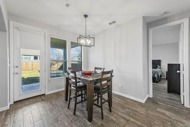 dining room with a chandelier and dark wood-type flooring