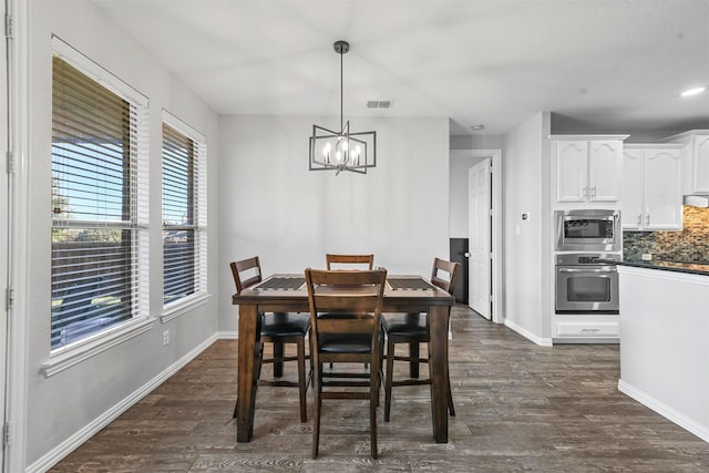 dining space with a chandelier and dark hardwood / wood-style floors