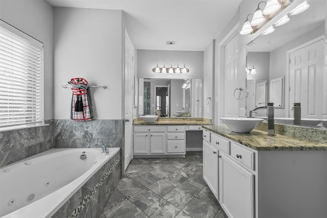 bathroom with vanity and a relaxing tiled tub