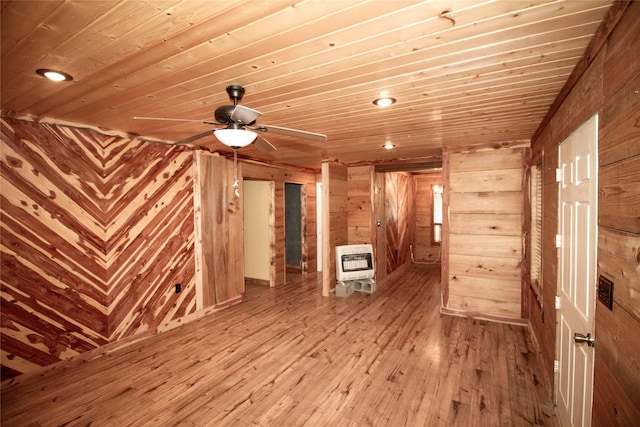 spare room featuring heating unit, ceiling fan, wood walls, and wood ceiling