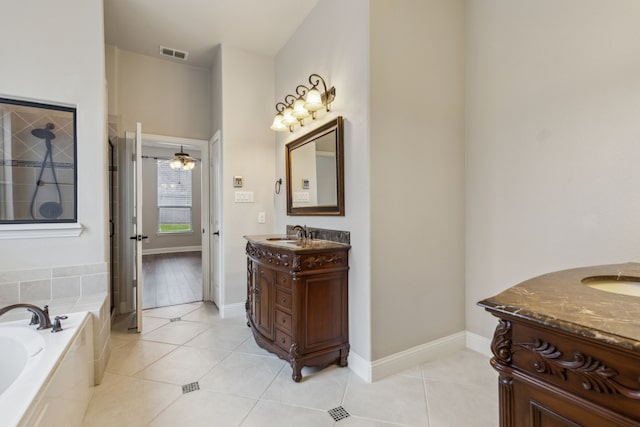 bathroom featuring tile patterned flooring, vanity, ceiling fan, and tiled tub