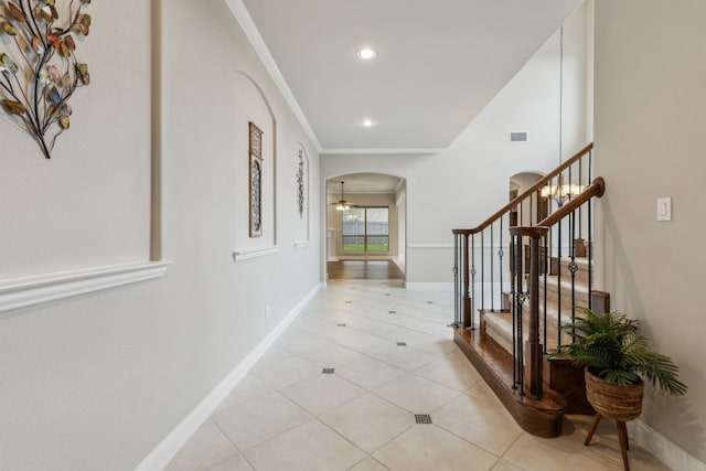 corridor with light tile patterned flooring and crown molding