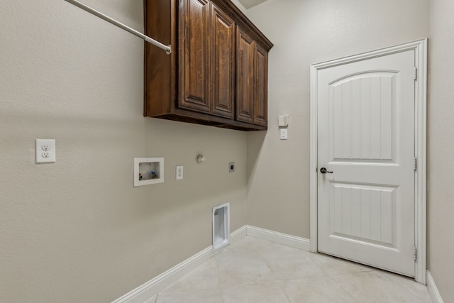 washroom with gas dryer hookup, cabinets, washer hookup, light tile patterned floors, and hookup for an electric dryer