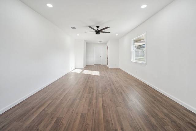 empty room with ceiling fan and dark hardwood / wood-style flooring